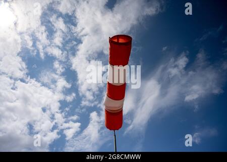 19 luglio 2021, Meclemburgo-Pomerania occidentale, Altefähr: Un ventoso si erge quasi orizzontalmente nell'aria e indica quindi un vento abbastanza forte. Foto: Stefan Sauer/dpa/ZB Foto Stock