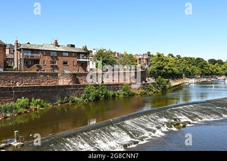 Chester, Inghilterra - Luglio 2021: Weir sul fiume Dee, che scorre attraverso la città. Sulla sinistra si trova una parte delle mura della città. Foto Stock