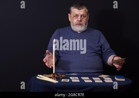 Bel ritratto a basso tasto dell'uomo caucasico anziano - soothsayer mentre fa la cartomanzia Foto Stock