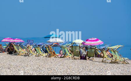 Birra, East Devon; 19 luglio 2021. Regno Unito Meteo: I vacanzieri godono del sole glorioso rilassarsi sulla spiaggia e rinfrescarsi nel mare blu presso il grazioso villaggio di pescatori e di mare di Beer, East Devon. Credit: Celia McMahon/Alamy Live News Foto Stock