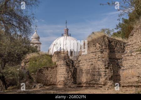 Chiesa rurale Sain Nicholas di Bari, dietro case in rovina in Catamarca Argentina. Foto Stock
