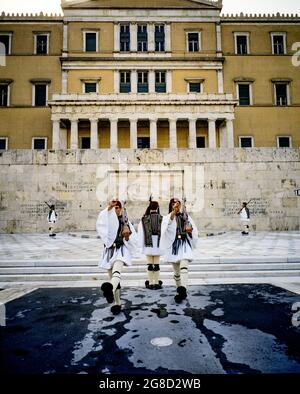 Atene, le guardie presidenziali di Evzones montano la guardia alla tomba del monumento soldato sconosciuto, edificio del Parlamento greco di Vouli, Grecia, Europa, Foto Stock