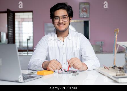 Ritratto di un giovane studente maschio in laboratorio che esegue esperimenti in laboratorio Foto Stock
