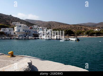 Isola di Sikinos Grecia. Aloprina villaggio, il porto delle isole. Vista sulla baia con spiaggia di sabbia fine e sul fronte del porto. Cielo blu. Spazio di copia. Foto Stock