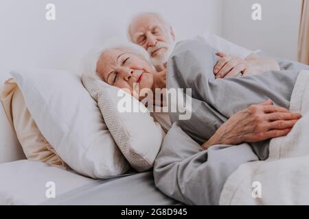 Bella coppia anziana che si gode il tempo insieme a casa - anziani che dormono a letto a casa Foto Stock