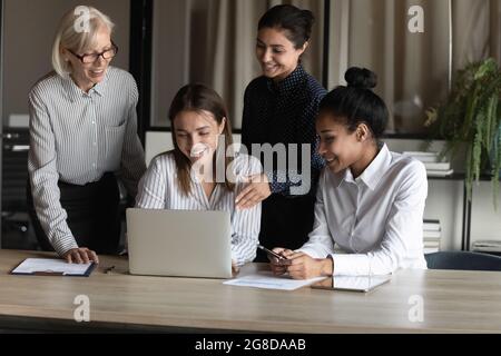 Gruppo di lavoro femminile felice e diversificato che lavora insieme al progetto Foto Stock