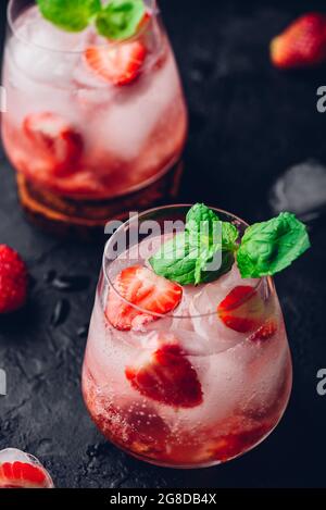 Cocktail con fragole fresche e surgelate, vodka e tonico in due bicchieri Foto Stock