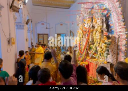 Immagine offuscata di adorazione, i fiori sono gettati, le preghiere fatte e Pushpanjali che sono offerti dai devoti indù alla Dea Durga a Shobhabazar Rajbari Foto Stock