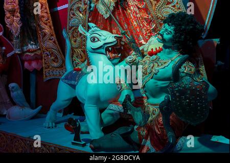 Idol del leone che uccide Mahishasura o Asura, a Durga Puja decorato pandal ai piedi di idol Durga, Durga Puja festival di notte. Sparato sotto la ligh colorata Foto Stock