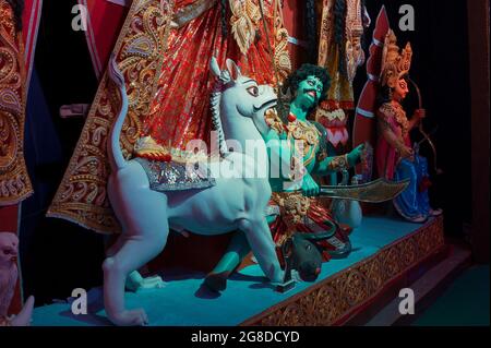 Idol del leone che uccide Mahishasura o Asura, a Durga Puja decorato pandal ai piedi di idol Durga, Durga Puja festival di notte. Sparato sotto la ligh colorata Foto Stock