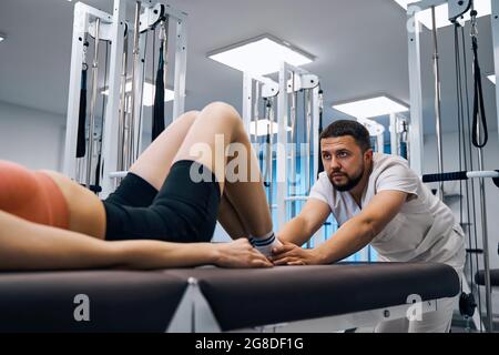 Primo piano uomo fisioterapista massaggiare i pazienti piede nella sala di fisioterapia. Terapista massaggiatore Foto Stock