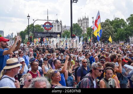 Londra, Regno Unito. 19 luglio 2021. Una folla di manifestanti si riuniscono intorno alla stazione di Westminster in Parliament Square. I dimostranti si sono riuniti a Westminster il giorno della libertà, il giorno in cui la maggior parte delle restrizioni sul coronavirus è stata revocata in Inghilterra, per protestare contro le vaccinazioni COVID-19, i passaporti per i vaccini e tutte le restrizioni rimanenti. (Credit: Vuk Valcic / Alamy Live News) Foto Stock