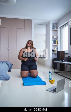 Donna afro-americana sognante che fa la sua routine di yoga mattutina Foto Stock