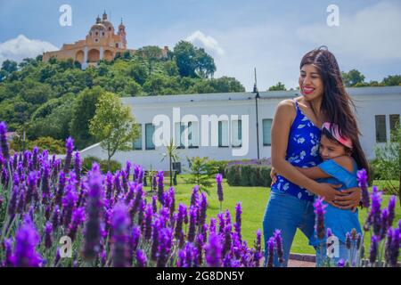 Madre abbracciando sua figlia in piedi in un campo di lavanda Foto Stock