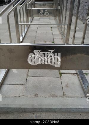parcheggio per biciclette vuoto vicino al centro commerciale. emblema per biciclette tagliato su una superficie metallica Foto Stock