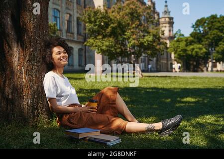 Donna che guarda felice mentre si rilassa nel parco Foto Stock