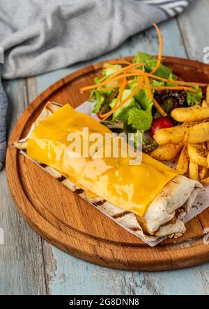 burrito di formaggio cheddar con patatine fritte e insalata. Foto Stock