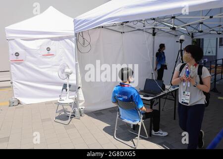 Una donna che indossa una maschera facciale come misura preventiva contro la diffusione di Covid-19 passa un punto di controllo per la misurazione della temperatura corporea allo Stadio Nazionale di Shinjuku.Tokyo è all'interno del quarto stato di emergenza e le misure di sicurezza di Tokyo 2020 hanno trasformato i luoghi olimpici in fortezze barricate. La polizia, le forze giapponesi di autodifesa, le società di sicurezza private e i volontari sorvegliano gli stadi e le strade vicine per impedire al pubblico di avvicinarsi troppo. Con queste misure gli organizzatori dei Giochi Olimpici di Tokyo 2020 cercano di minimizzare i rischi per la salute posti dalla sp Foto Stock