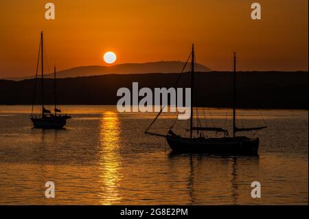 Baltimora, West Cork, Irlanda. 19 luglio 2021. Il sole tramonta su Baltimora dopo una giornata di sole e temperature elevate. MET Éireann ha emesso un avviso di "alta temperatura" per il resto della settimana, poiché si prevedono temperature fino a venti anni. Credit: AG News/Alamy Live News Foto Stock