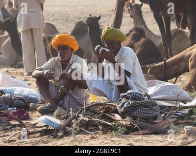 Due uomini che prendono una rottura al mercato del cammello di Pushkar, Rajasthan, India Foto Stock