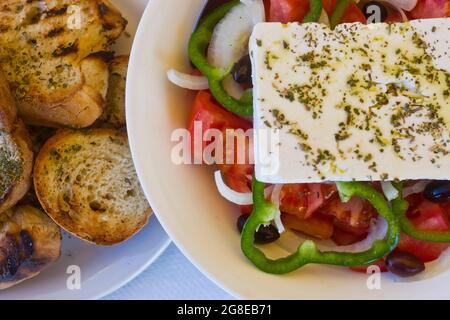 Un'insalata greca tradizionale con pane all'aglio in un ristorante a Creta, Grecia Foto Stock