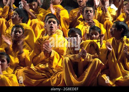 Adoratori estatici alla cerimonia aarti al tramonto sulle rive del Gange sacro, Rishikesh, Uttarakhand, India Foto Stock