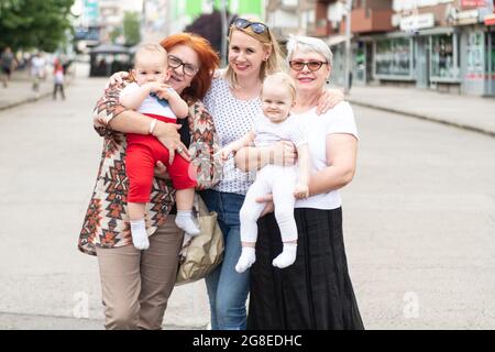 Generazione Ritratto di una felice due nonna con sua figlia, nipote e nipote passare il tempo insieme in città Foto Stock