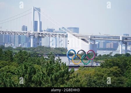 Gli anelli olimpici del Parco Marino di Odaiba con lo sfondo del Ponte dell'Arcobaleno prima dei Giochi Olimpici di Tokyo 2020 in Giappone. Data immagine: Martedì 20 luglio 2021. Foto Stock