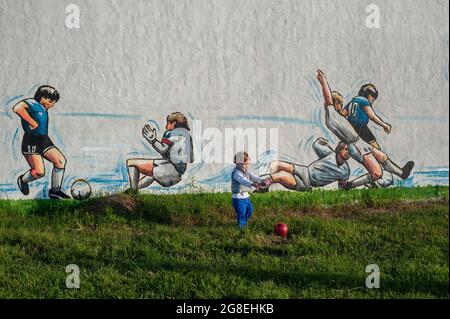 Firmat, Argentina. 12 maggio 2018. Un ragazzino è visto di fronte ad un murale che celebra la figura della leggenda del calcio ritardato Diego Armando Maradona è visto in Firmat. Il murale dell'artista Ariel Bertolotti rappresenta il leggendario obiettivo contro la squadra inglese nella Coppa del mondo del Messico 86, con una svolta: L'obiettivo non è celebrato da Maradona ma dalla stella di oggi Lionel messi. Maradona morì all'età di 60 anni il 25 novembre 2020 di grave insufficienza cardiaca in circostanze ancora sotto inchiesta. (Foto di Patricio Murphy/SOPA Images/Sipa USA) Credit: Sipa USA/Alamy Live News Foto Stock