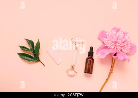 Cosmetici fiale di olio essenziale pulire morbido asciugamano rosa rullo di quarzo massaggiatore facciale pietra di Gua-sha per il massaggio di bellezza del viso Foto Stock