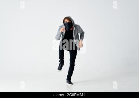 uomo con cappuccio che indossa maschera anonimato furto bully sneaks Foto Stock