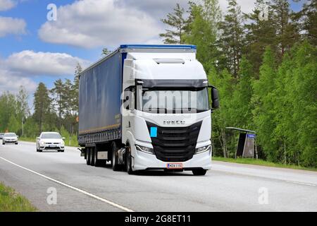 Nuova Iveco S-Way Natural Power, NP, alimentata a gas bianco, camion davanti al semirimorchio sull'autostrada 25 in una giornata di sole. Raasepori, Finlandia. 27 maggio 2021. Foto Stock