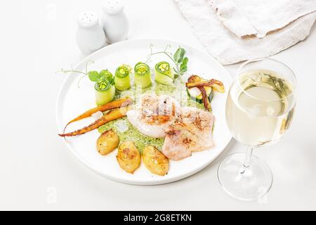 Primo piano calamari alla griglia con verdure. Calamari con patate novelle, zucchine, verdure fresche di stagione e salsa alle erbe. Cucina Mediterranea. Foto Stock