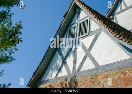 Muro di timpano di casa tipica a graticcio con primo piano in mattoni in Germania di fronte al cielo blu Foto Stock