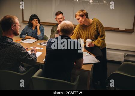 Donna professionista che ha una riunione con il team in sala riunioni. donna d'affari che ha una riunione in conferenza con i colleghi. Foto Stock
