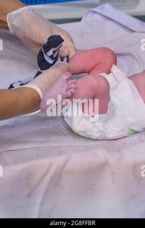 Calzino per medicazione un neonato da un medico subito dopo il parto Foto Stock