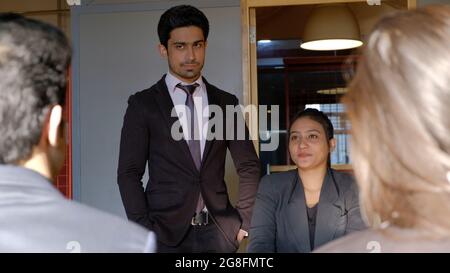 Colleghi indiani seduti intorno a un tavolo e discutere il loro nuovo progetto Foto Stock