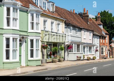 Colorate case a schiera e aziende in Alresford, una bella città georgiana dell'Hampshire, Inghilterra, Regno Unito. Vista lungo East Street. Foto Stock