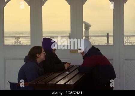 La lunga passerella in legno del Victorian Palace Pier presenta aree salotto con pannelli in legno che proteggono il pubblico da condizioni atmosferiche avverse e venti Foto Stock