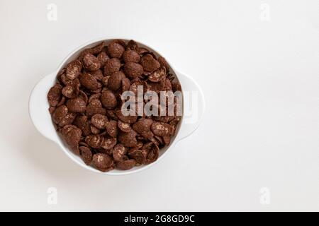scaglie di cioccolato in ciotola isolato su sfondo bianco, sano concetto di colazione, piatto di cornflakes Foto Stock