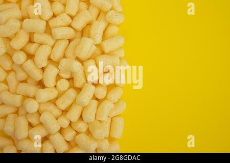 mucchio di bastoncini di mais dolce con ampio spazio per il testo isolato su sfondo giallo, vista dall'alto Foto Stock