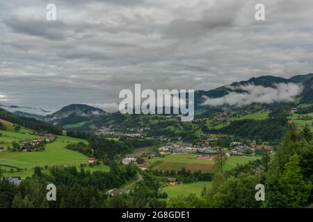 Colline e valle nei pressi di Sankt Johann im Pongau con nebbia e prati verdi freschi Foto Stock