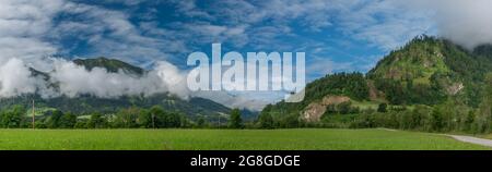 Colline e valle nei pressi di Sankt Johann im Pongau con nebbia e prati verdi freschi Foto Stock