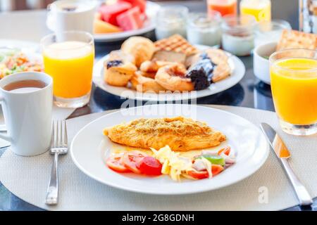 Colazione a buffet in hotel di lusso, omelette e dessert freschi, panini, croissant Foto Stock