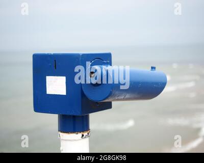 Vista ravvicinata di un telescopio a gettoni che si affaccia su una spiaggia sul mare Foto Stock