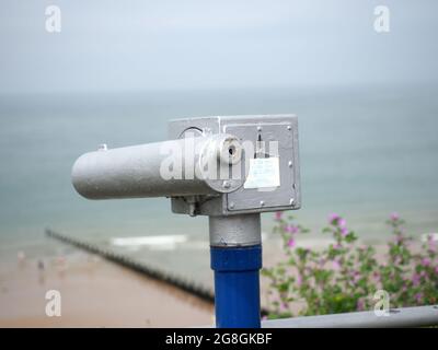 Vista ravvicinata di un telescopio a gettoni che si affaccia su una spiaggia sul mare Foto Stock