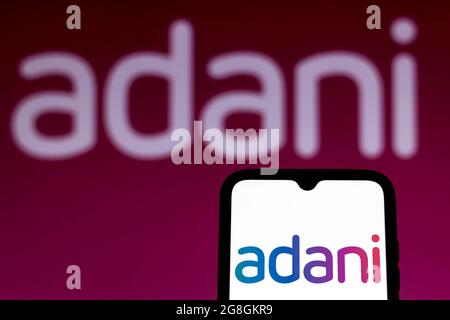 In questa illustrazione fotografica viene visualizzato il logo del Gruppo Adani sullo schermo di uno smartphone e sullo sfondo. Foto Stock