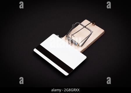 Rischio di credito e trappola di prestito - modello bianco carta di credito in legno mouse trappola su sfondo nero Foto Stock