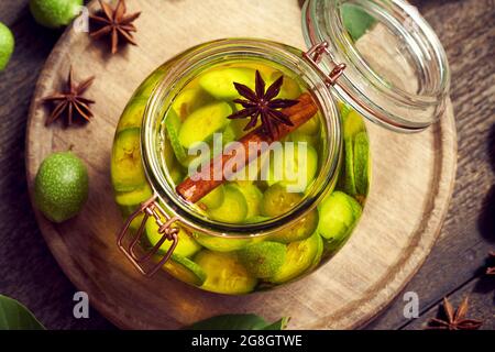 Macerazione di acerbe noci e spezie in alcool in un vaso, per preparare in casa il dado di liquore, vista dall'alto Foto Stock