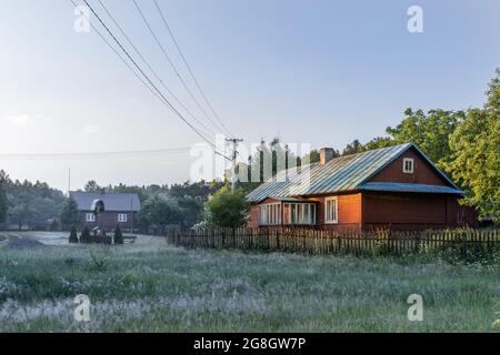 Luogo idilliaco di villaggio polacco situato nel mezzo della foresta. Mattina nebbia sui campi. Krasnobród, Roztocze, Polonia. Foto Stock